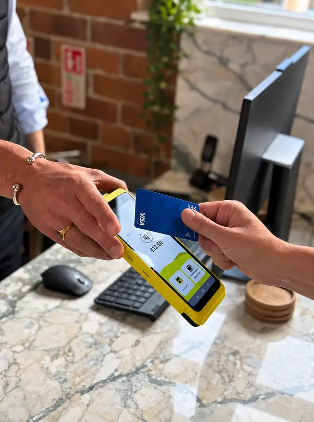 Customer paying by contactless card on a portable card machine