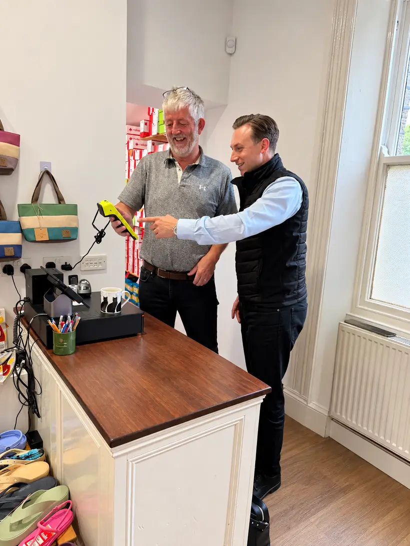 Pennine Payments setting up a new card machine for a shop owner